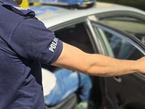 zatrzymany w radiowozie, policjanta ręka zamyka drzwi