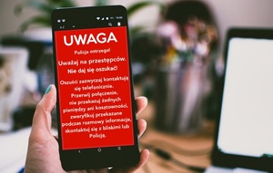 telefon trzymany w ręce z ostrzeżeniami jak nie dać się oszukać