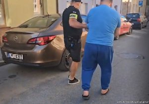 zatrzymany w kajdankach prowadzony przez policjantów