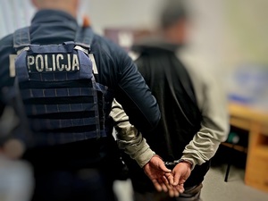 zatrzymany z narkotykami prowadzony w kajdankach przez policjanta
