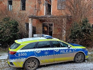 działania w ramach akcji Zima, policjanci sprawdzają pustostany pod kątem osób potrzebujących, radiowóz zaparkowany przed jednym z takich miejsc