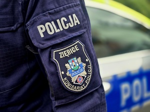 naszywka na mundurze z Komisariatu Policji Ziębicach, w tle radiowóz