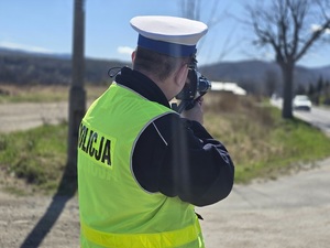 policjant umundurowany z ręcznym miernikiem prędkości