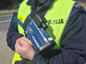 policjant umundurowany z ręcznym miernikiem prędkości