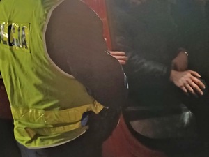 policjant i mężczyzna w nocy przy pojeździe