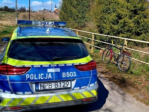 rower i radiowóz na drodze w dzień