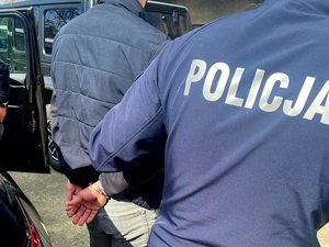 zatrzymany w kajdankach prowadzony przez policjanta