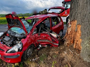 zdarzenie drogowe, czerwony samochód osobowy uderzył w drzewo
