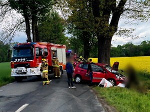 samochód osobowy koloru czerwonego uderzył w drzewo