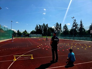policjant przeprowadzający egzamin na kratę rowerowa w szkole z dziećmi
