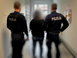 kobieta zatrzymana za kradzież, prowadzona przez 2 umundurowanych policjantów