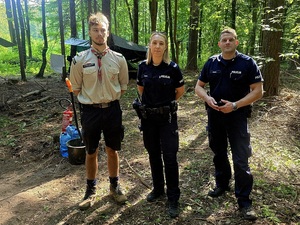 policjanci na obozie harcerskim w lesie z harcerzami
