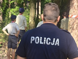 policjanci na obozie harcerskim w lesie z harcerzami