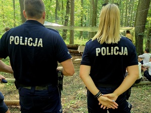 policjanci na obozie harcerskim w lesie z harcerzami