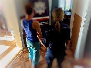 kobieta w kajdankach prowadzona przez policjantkę