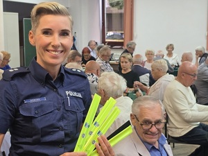 policjantka rozdaje odblaski podczas Igrzysk Sportowych Seniorów