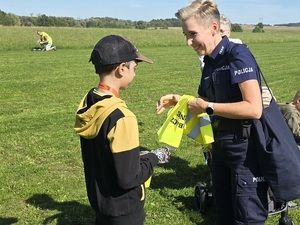 policjanci rozdają odblaski podczas powiatowego rajdu rowerowego