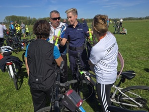 policjanci rozdają odblaski podczas powiatowego rajdu rowerowego