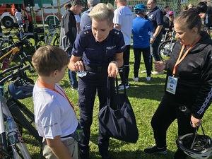 policjanci rozdają odblaski podczas powiatowego rajdu rowerowego